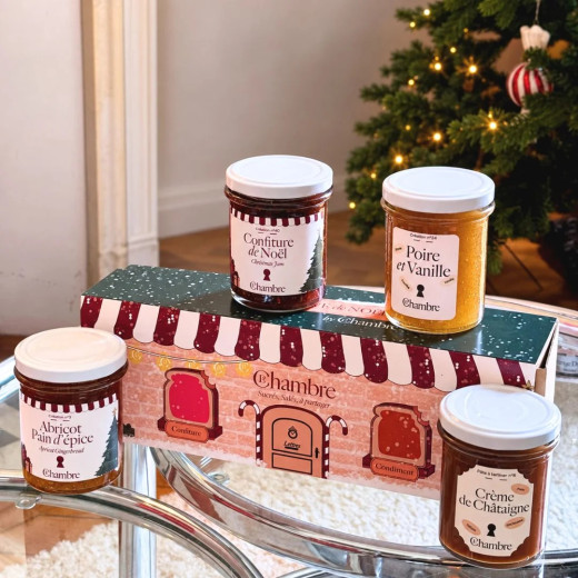 Les quatre pots de 200 g du coffret de Noël devant un sapin décoré : Noël, poire-vanille, abricot pain d'épice, châtaigne