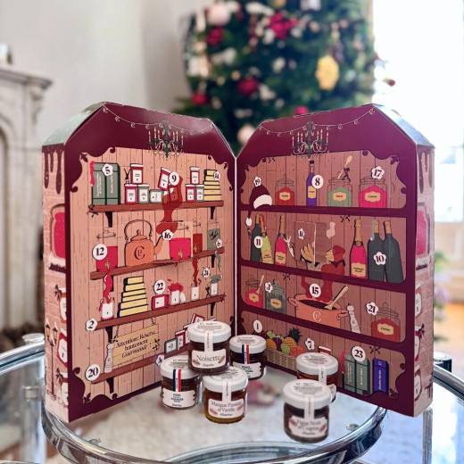 Le calendrier de l'Avent ouvert, ses cases numérotées et six mini pots de confitures et de pâtes à tartiner