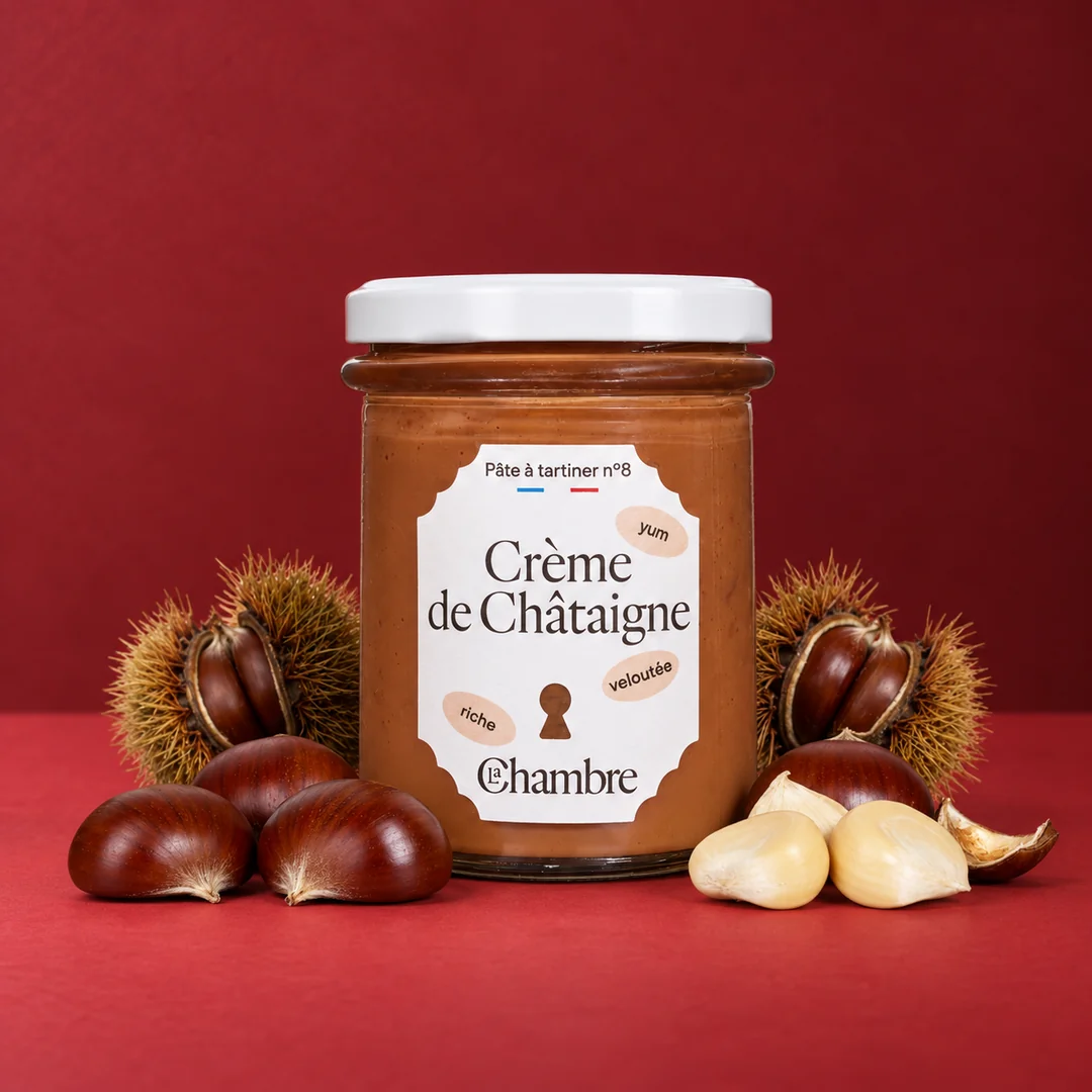 Pot de Crème de Châtaigne de La Chambre sur fond rouge, entouré de châtaignes dans leur bogue et de châtaignes épluchées