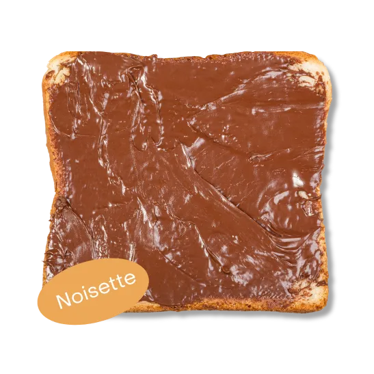 Une tartine généreusement garnie de pâte à tartiner à la noisette de la marque la chambre à côté du pot